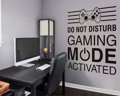 a computer desk with a monitor and keyboard on it in front of a wall that says don't disturb gaming mode activated