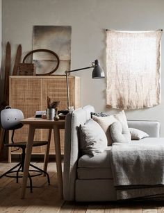 a living room with a couch, table and chair next to a window in the corner