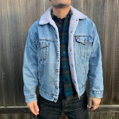 "This denim jacket is well made by Levi in the USA, the jacket is lightly worn but still sturdy and the vintage wear gives it a great worn in look. Beautiful steel snaps complete this classic button up jacket. White synthetic shearling and 100 cotton denim. The classic leather tag shows the size M underneath it. Jacket is men's sizing but is a unisex design. -Model size women's medium/large. -Model size men's large. Approximate measurement when laid flat: 25\" armpit to armpit 21\" shoulder to s Winter Denim Blue Outerwear With Buttons, Denim Blue Winter Outerwear With Buttons, Vintage Selvedge Denim Blue Outerwear, Vintage Selvedge Denim Outerwear, Winter Streetwear Denim Jacket With Selvedge, Dark Wash Buttoned Winter Outerwear, Rugged Denim Jacket With Pockets For Winter, Vintage Denim Outerwear For Winter, Long Sleeve Dark Wash Selvedge Outerwear