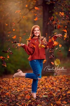 a woman is running through leaves with her arms spread out to catch the falling leaves