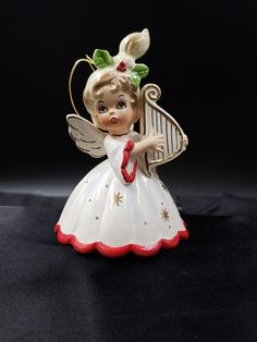 an angel figurine with a red and white dress