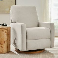 a white recliner chair sitting in a living room next to a wooden side table