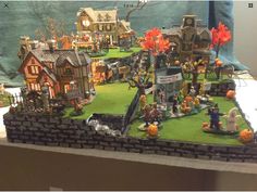 this is a fake halloween town with pumpkins on the ground and houses in the background