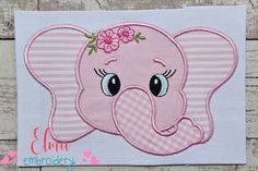 an elephant with pink flowers on its head is embroidered onto the side of a piece of fabric