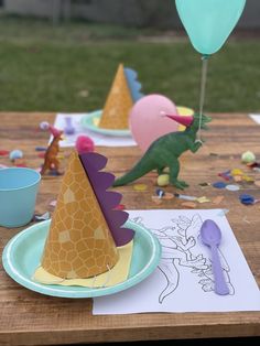 a table topped with plates and paper hats on top of a wooden table covered in confetti