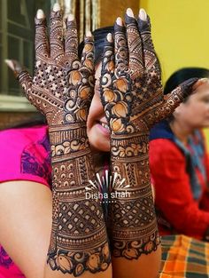 a woman with her hands covered in henna