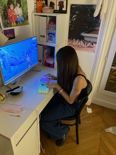 a woman sitting in front of a computer desk with a keyboard and mouse on it