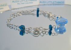 Blue beaded wire bracelet. It measures approx. 7 inches long and has a hook closure. Made with a round cornflower blue glass cabochon in the center, 4 deep turquoise blue glass square beads and swirling Peruvian Alpaca Silver wire chain. Handmade, delicate and light weight. Add it to your jewelry wardrobe. All sales are final and as is. Thank you for looking. You may also love this: https://www.etsy.com/listing/236165636/red-murano-glass-tear-drop-earrings-hoop?ga_search_query=murano&ref=sho Adjustable Blue Wire Wrapped Beaded Bracelets, Adjustable Nickel Free Blue Jewelry, Adjustable Nickel-free Blue Jewelry, Adjustable Blue Wire Wrapped Bracelets, Blue Wire Wrapped Beaded Bracelets As Gift, Wire Wrapped Blue Beaded Bracelets For Gift, Wire Wrapped Blue Beaded Bracelets As Gift, Blue Wire Wrapped Beaded Bracelet For Gift, Wire Wrapped Blue Beaded Bracelet As Gift