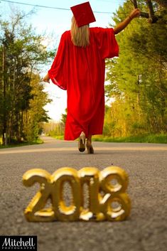 a person in a red graduation gown is walking down the street with his arms outstretched