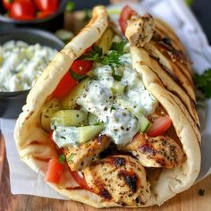 a chicken pita sandwich with cucumbers, tomatoes and tzatzts