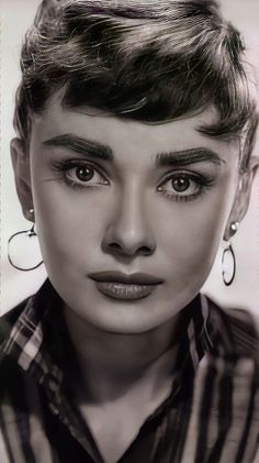 black and white photograph of a woman's face with large earrings on her head