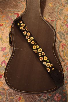 a guitar strap with flowers on it