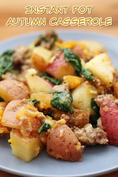 a blue plate topped with potatoes and spinach on top of a wooden table next to a