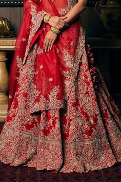 Scarlet red flared lehenga with all over rafflesia garden embroidery using zardozi multi thread, dori, pearls and sequin highlights. Paired with a half sleeves cutwork border blouse with paisley floral embroidery, a veil and floral garden embroidered organza dupatta. - Aza Fashions Red Floor-length Sharara For Reception, Red Floor-length Lehenga With Cutdana, Red Gown With Sheer Dupatta For Diwali, Red Anarkali Floor-length Lehenga, Red Semi-stitched Sharara For Reception, Red Anarkali Lehenga With Sheer Dupatta, Red Semi-stitched Lehenga With Sheer Dupatta, Red Floor-length Lehenga With Sheer Dupatta, Red Floor-length Choli For Diwali