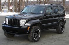 a black jeep parked in a parking lot