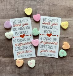 three cards with conversation hearts on them sitting on top of a wooden table next to each other