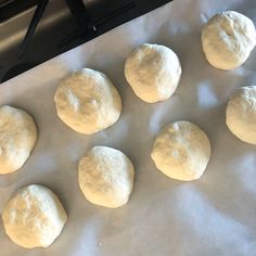 six doughnuts on a baking sheet ready to go into the oven for cooking