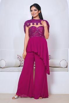 Wine peplum kurta with cutdana hand embroidered yoke and asymmetric hem. Paired with a plain sharara and cape with matching hand embroidery. - Aza Fashions Elegant Purple Reception Sets, Elegant Peplum Sharara For Party, Elegant Fitted Purple Sharara, Elegant Purple Sharara For Party, Elegant Purple Sharara For Reception, Sleeveless Purple Party Set, Elegant Purple Georgette Sharara, Elegant Sleeveless Set For Reception, Elegant Sleeveless Reception Set