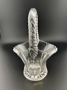 a clear glass vase with a twisted handle