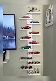 there are many toy cars on the shelves next to the tv and framed photograph in front of it