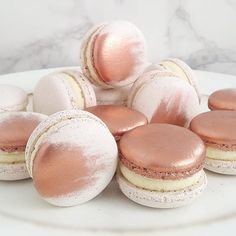 some macaroons are sitting on a plate with pink powdered doughnuts