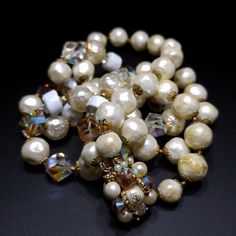 *Description: This is a beautiful unsigned designer necklace with a decorative hidden box clasp and two strands of faux pearls and irregular cut crystal beads in champaign and clear with aurora borealis. The vintage Swarovski Helix beads which feature an irregular shape and multiple facets create a sparkling look anywhere.  The necklace also has art beads that are white with traces of gold and gold plated end caps.  It is a beautiful necklace and would be a great addition to your vintage jewelry Vintage Multi-strand Jewelry For Party, Vintage White High Luster Jewelry, Vintage Pearl Jewelry For Evening, Evening Costume Jewelry With Faceted Beads, Costume Jewelry With Faceted Beads For Evening, Vintage Pearl Beaded Bracelet, Vintage Beaded Pearl Necklace For Party, Vintage Single Strand Jewelry For Party, Evening Beaded Pearl Necklace In Costume Jewelry Style