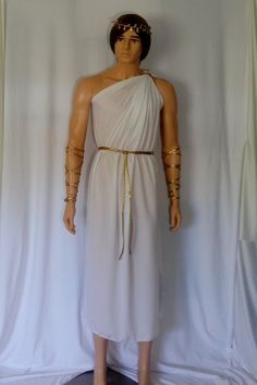 a mannequin wearing a white dress with gold chains on it's arms