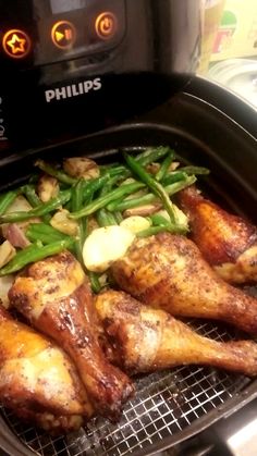 chicken and green beans cooking in an air fryer