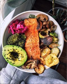 a white bowl filled with vegetables and fish