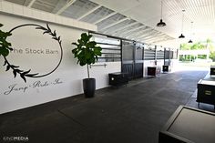 the interior of a stock barn with black and white decor on the wall, potted plants in front of the sign