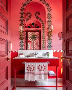 a bathroom with red walls and white counter tops