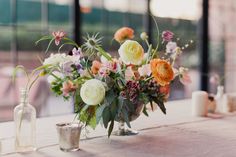 a vase filled with lots of flowers on top of a table