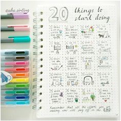 an open notebook with markers and pens on it