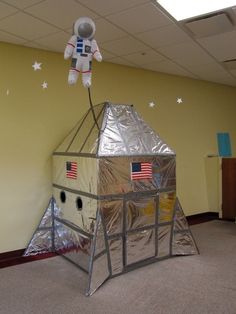 an astronaut's house made out of tin foil in the middle of a room