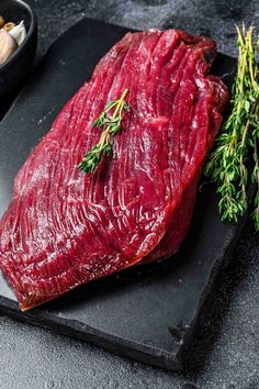 a piece of raw meat sitting on top of a cutting board