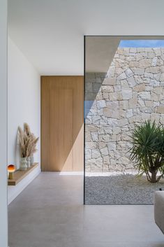 the interior of a modern house with stone walls