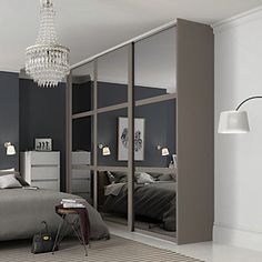 a bedroom with a large bed and mirrored closets in the wall next to it