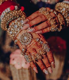 two hands with henna and jewels on them