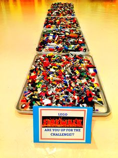 a long row of legos on display in a building with a sign that says fire walk are you up for the challenge?