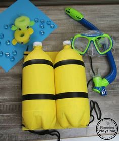 two yellow life vests, snorkelons and scuba gear on a wooden floor