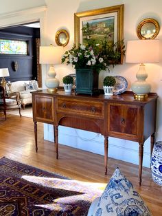 a living room filled with lots of furniture and flowers on top of a wooden table