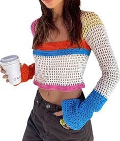 a woman holding a coffee cup and wearing a crochet top with sleeves on