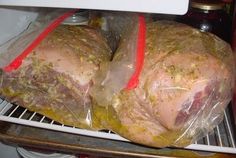 a turkey wrapped in plastic sitting on top of an open refrigerator