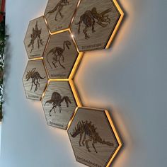 some wooden hexagonals with different types of dinosaurs on them are mounted to the wall