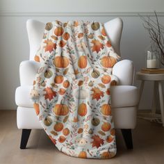 an orange and white fall themed blanket on a chair