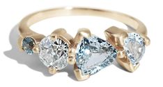 three pear shaped diamonds are on top of a yellow gold band, set in two different shapes