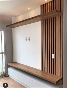 an empty room with wood paneling on the wall and wooden shelves in front of it