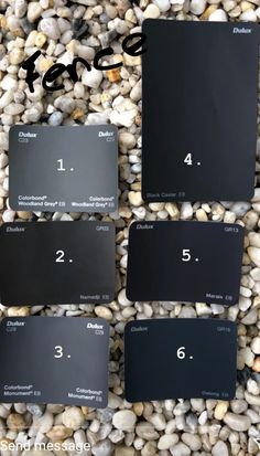 four different shades of black paint sitting on top of some white and gray rocks with the numbers