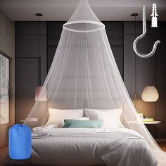 a bed with a mosquito net hanging from it's headboard and pillows on the floor