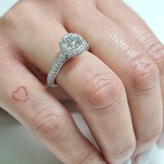 a close up of a person's hand with a diamond ring on their finger